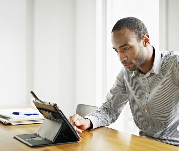 Businessman in office working on digital tablet