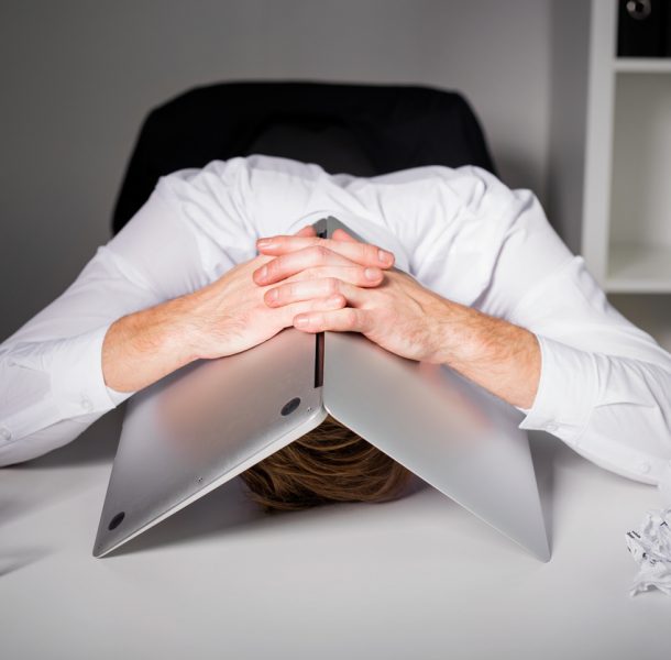 Man hiding under laptop