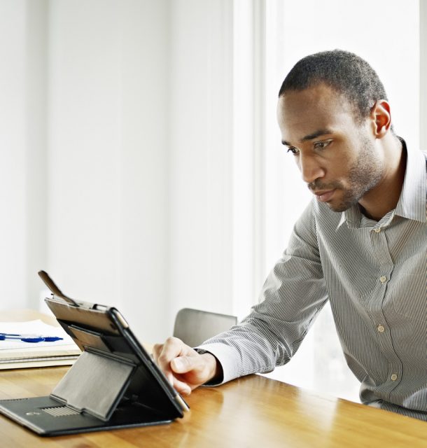 Businessman in office working on digital tablet